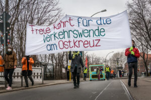 Demonstrant*innen mit Banner: Freie Fahrt für die Verkehrswende am Ostkreuz