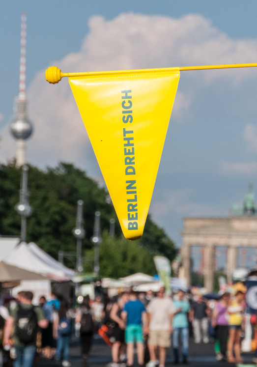 "Berlin dreht sich" Wimpel vor dem Berliner Fernsehturm und dem Brandenburger Tor