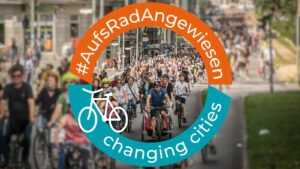 Foto von einer Fahrraddemonstration von vorne, darum ein runder Rahmen in orange und türkis der Text Hashtag Aufs Rad Angewiesen, ein Fahrrad-Icon und Changing Cities.