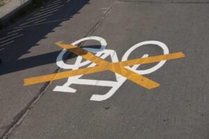 Foto von Asphalt: Eine aufgemalte weiße Fahrradwegmarkierung ist mit einem gelben X abgeklebt