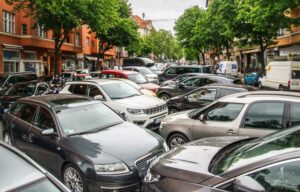 Verstopfte Stadtstraße mit dicht gedrängten Autos zwischen Bäumen und Geschäftsgebäuden