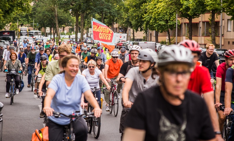 Fahrraddemonstration mit vielen Radfahrern; Fahne mit der Aufschrift „CHANGING CITIES“