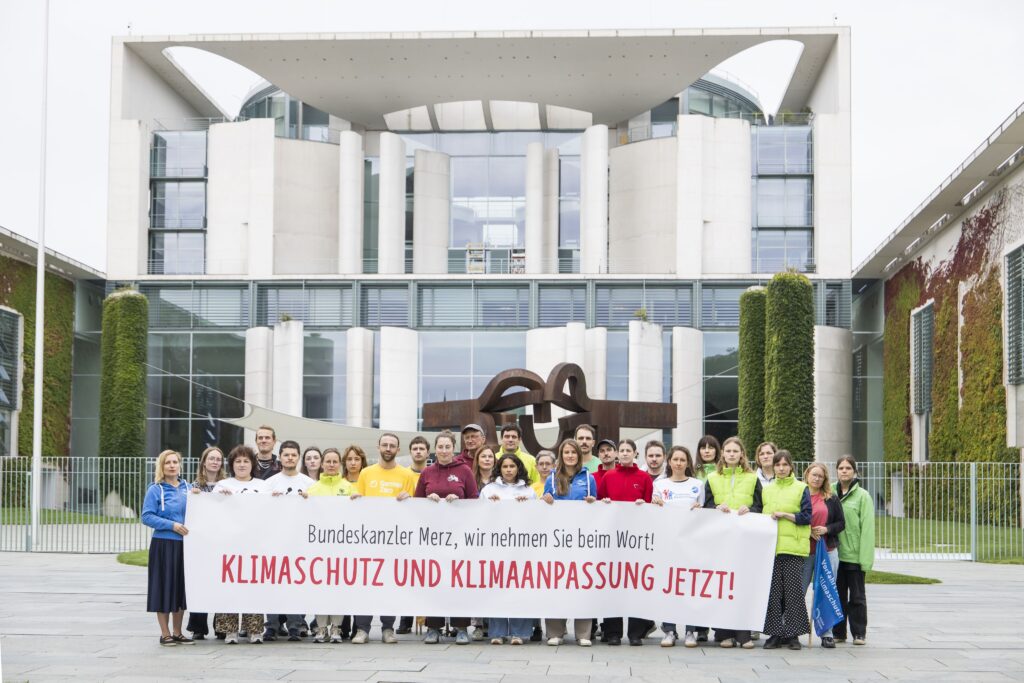 Gruppe demonstriert vor dem Kanzleramt mit Banner: „Klimaschutz und Klimaanpassung jetzt!“